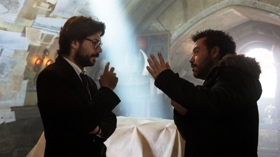 Professor Darsteller Álvaro Morte unterhält sich am Set mit Regisseur Jesús Colmenar.